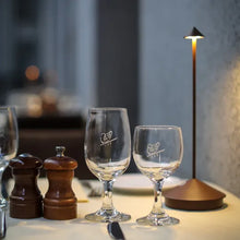 Lade das Bild in den Galerie-Viewer, Zwei Weingläser auf gedecktem Tisch mit Salz- und Pfefferstreuer, moderne Tischlampe.
